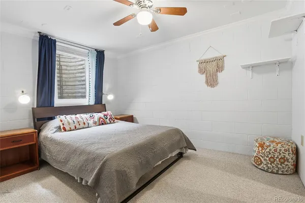 a bed sitting in a room next to a window and a chandelier