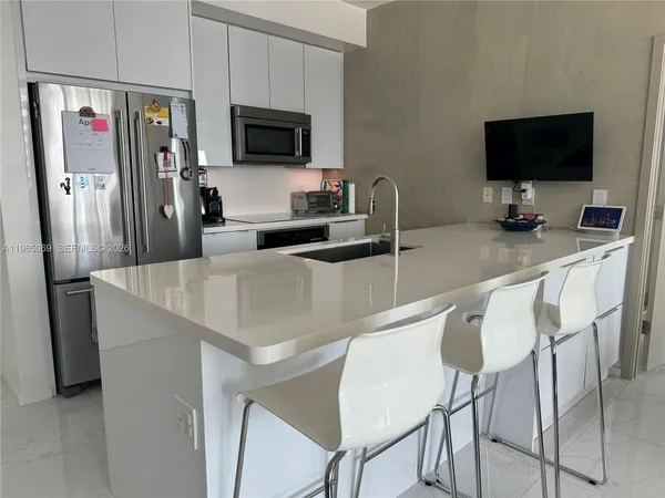 a kitchen with stainless steel appliances microwave stove refrigerator and a microwave