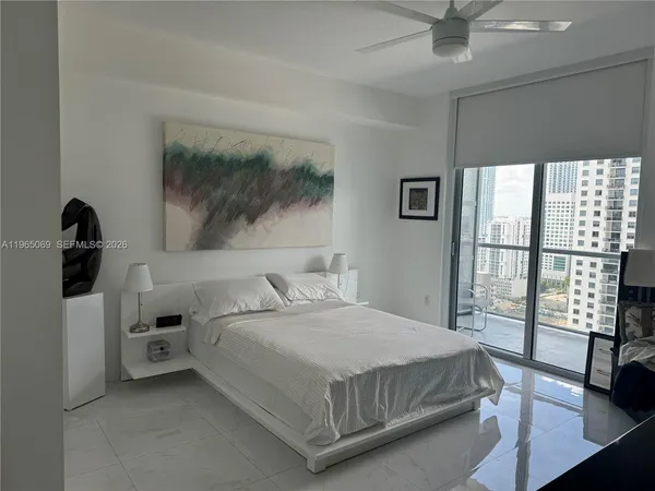 a bedroom with a bed and a large window