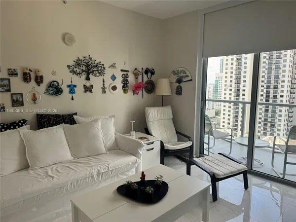 a living room with furniture and a floor to ceiling window