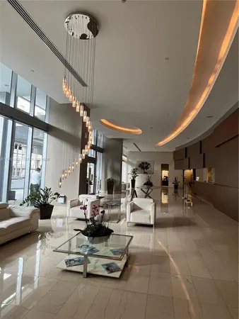 a living room with furniture and a chandelier