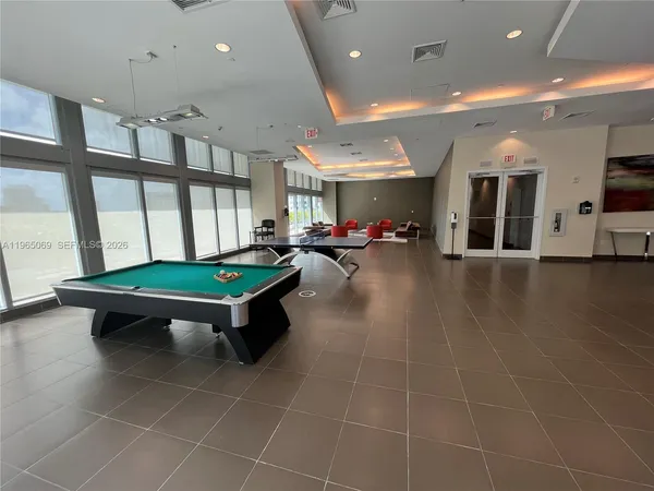 a room with pool table and windows
