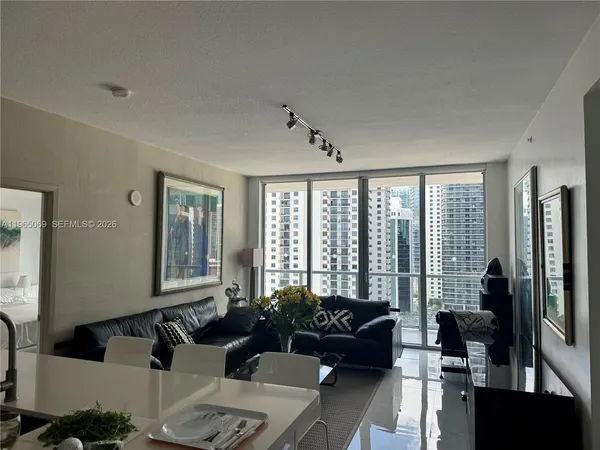 a living room with furniture and a floor to ceiling window