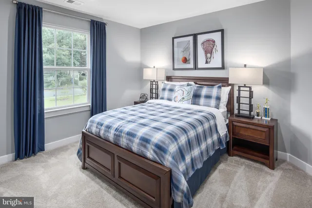 a bed sitting in a bedroom next to a window