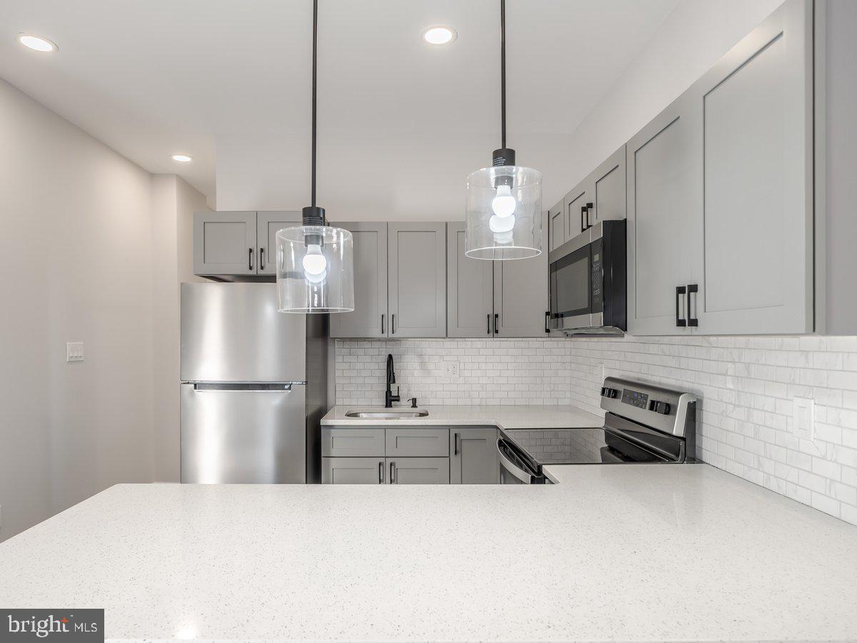 623 West Oxford Street Philadelphia, PA 19122 - Photo 19 of 39 a kitchen with stainless steel appliances granite countertop a refrigerator a stove a sink dishwasher and a refrigerator with wooden floor