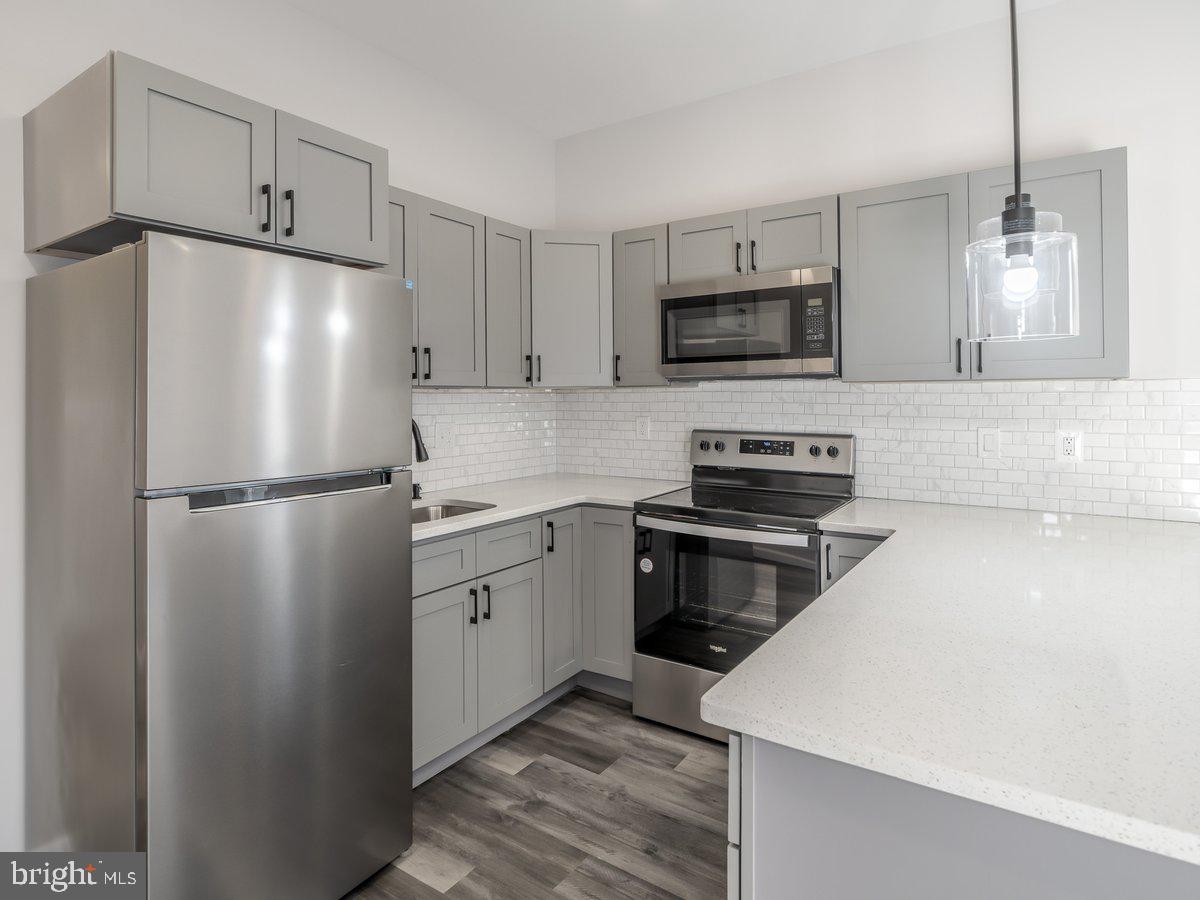 623 West Oxford Street Philadelphia, PA 19122 - Photo 20 of 39 a kitchen with stainless steel appliances granite countertop a refrigerator a stove a sink and a microwave