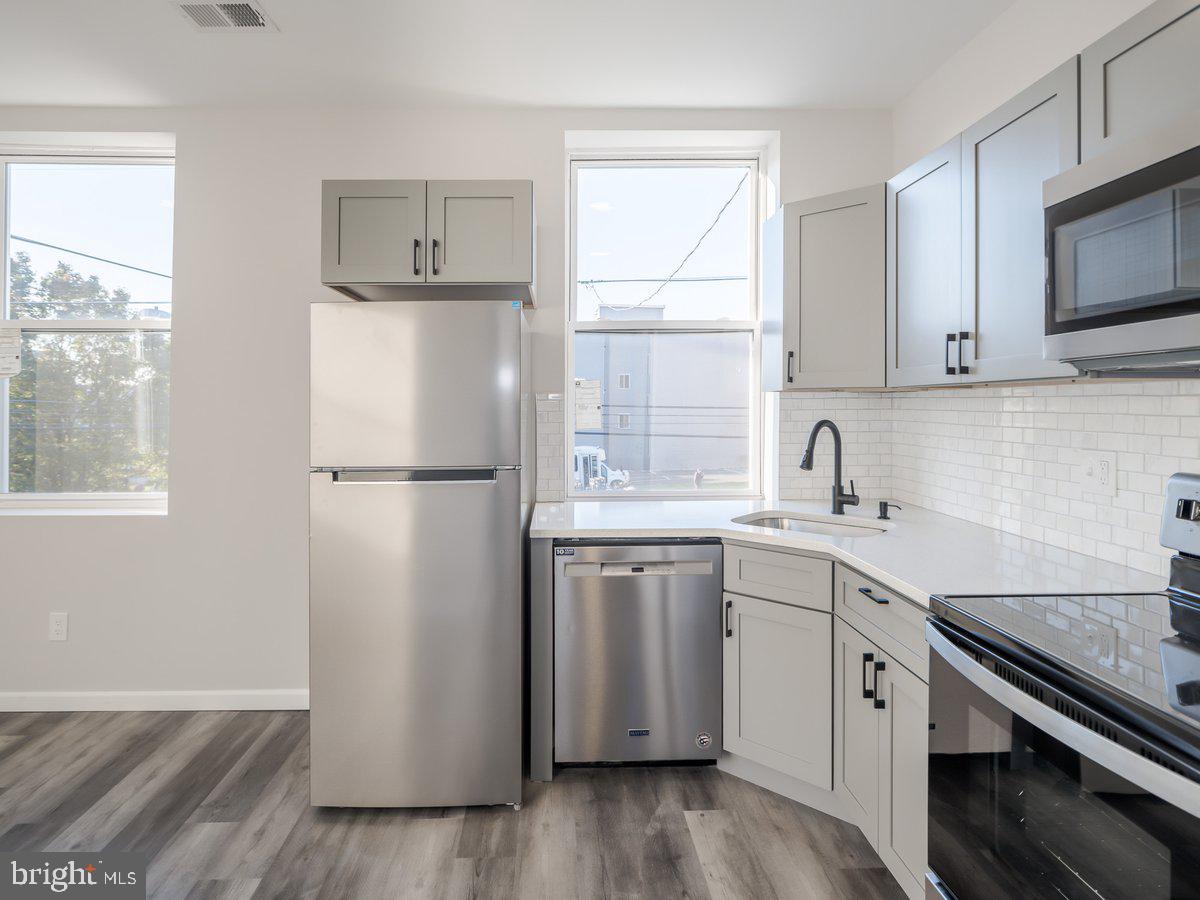 623 West Oxford Street Philadelphia, PA 19122 - Photo 28 of 39 a kitchen with a sink cabinets stainless steel appliances and a window