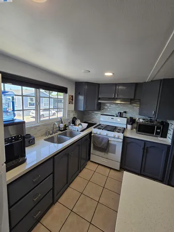 a kitchen with stainless steel appliances granite countertop a sink counter space cabinets and a large window