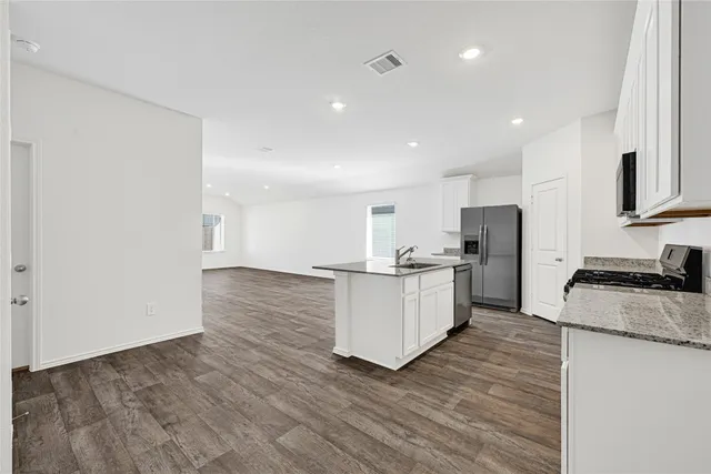 a kitchen with white cabinets and stainless steel appliances