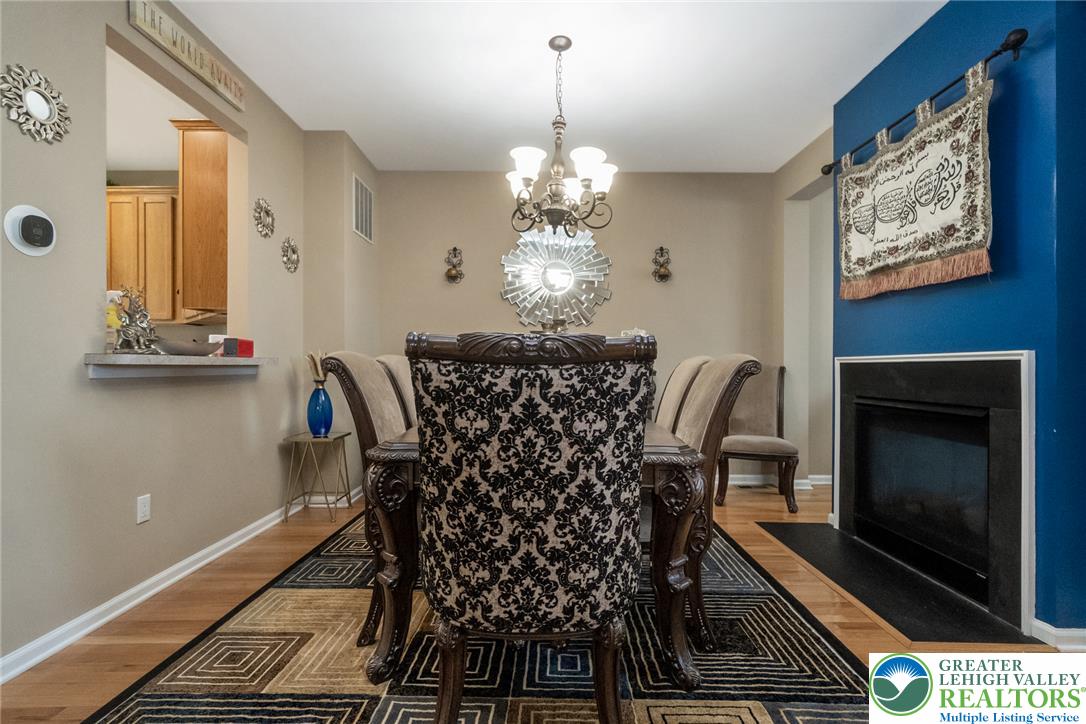 3566 Penfield Way Nazareth, PA 18064 - Photo 16 of 47 Hardwood flooring and a sleek 2-sided fireplace combine for a refined dining room aesthetic.