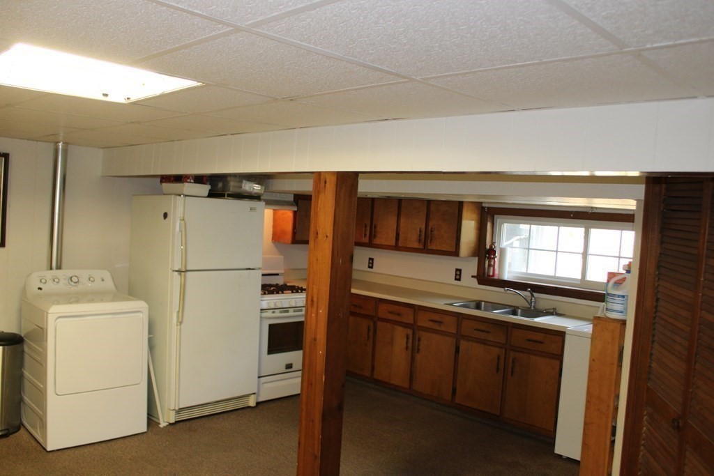 295 Draper Street Springfield, MA 01108 - Photo 25 of 31 a kitchen with stainless steel appliances a refrigerator a stove and white cabinets
