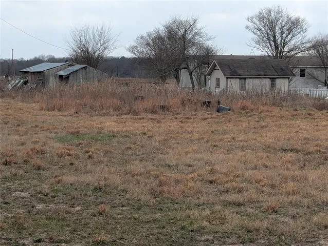 a view of a field with trees in the background