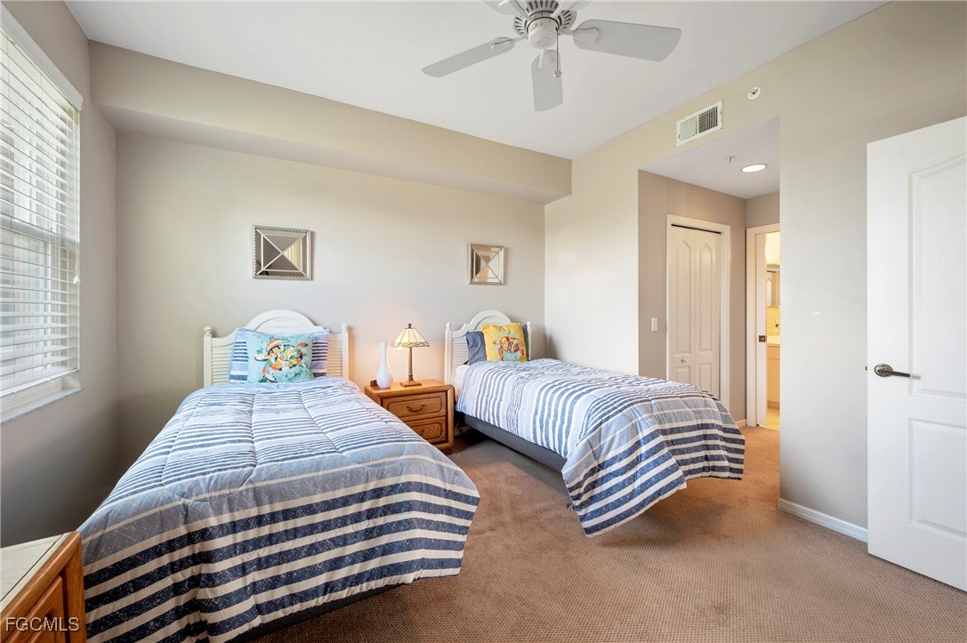14091 Brant Point Circle, Unit 4201 Fort Myers, FL 33919 - Photo 20 of 23 a bedroom with two beds and a chandelier