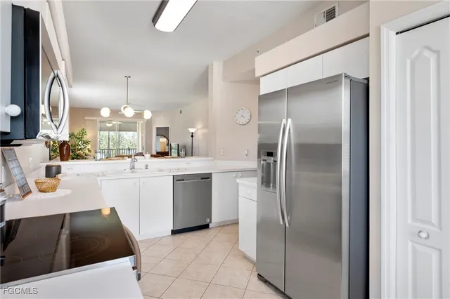 a kitchen with a sink stainless steel appliances and white cabinets