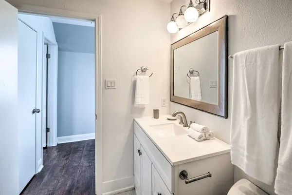 a bathroom with a sink vanity mirror and toilet