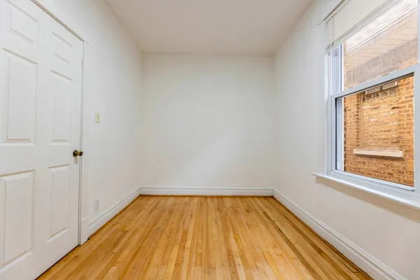 a view of a room with wooden floor and small window