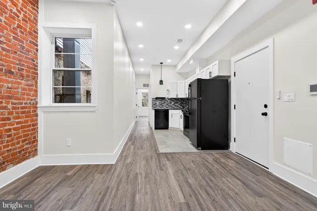a view of a kitchen with wooden floor and a refrigerator