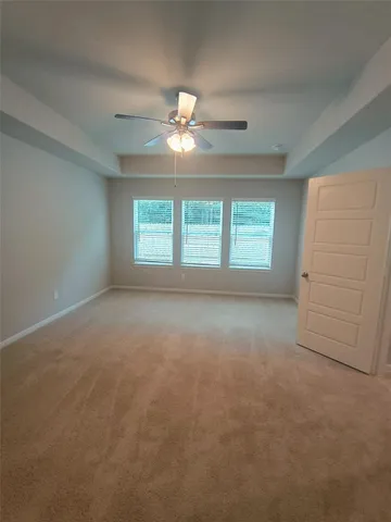 an empty room with windows and fan