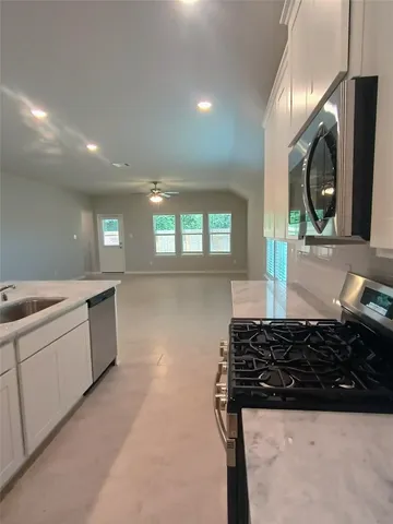 a kitchen with sink a stove and cabinets