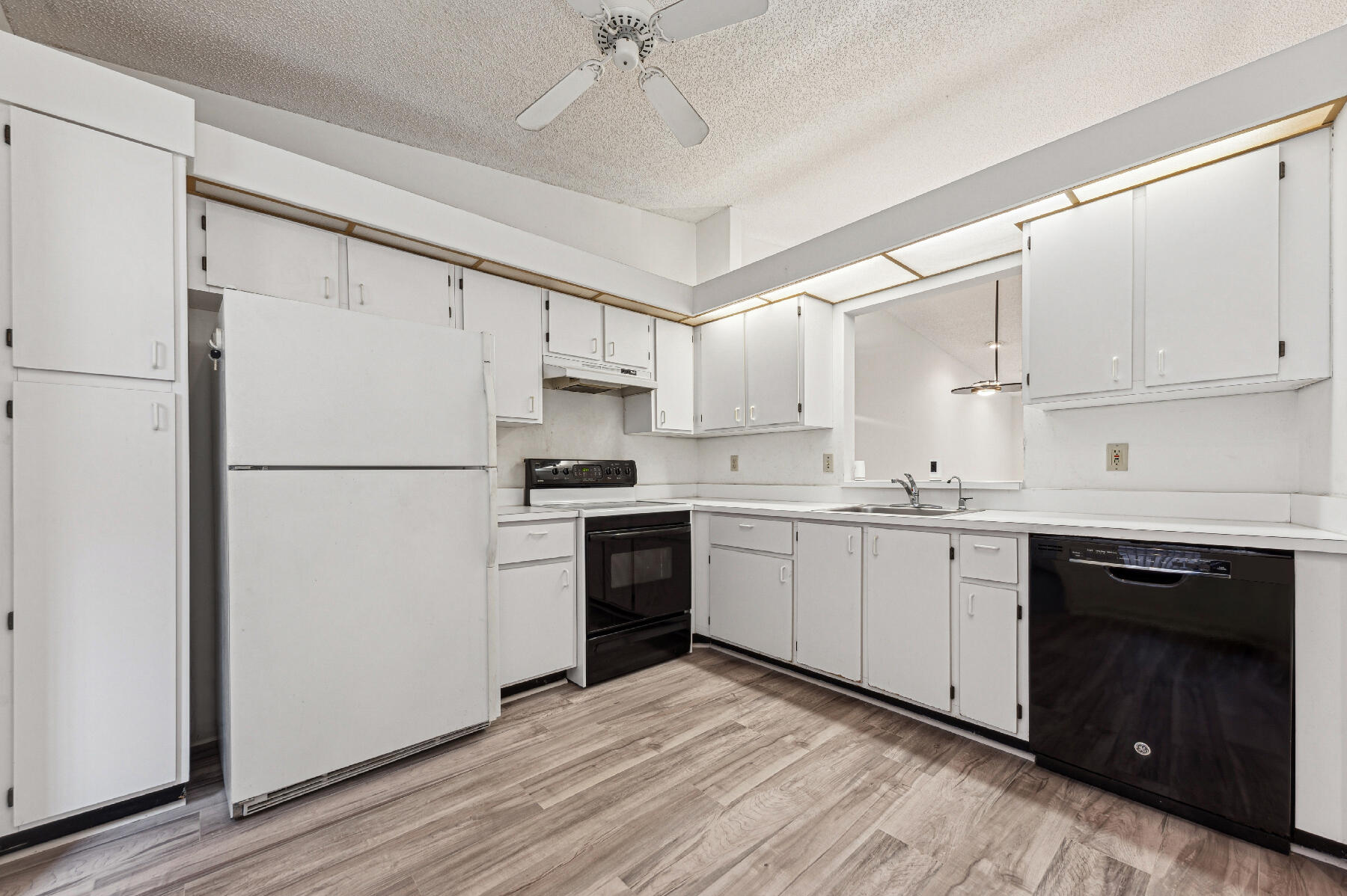 8191 Sweetbriar Way Boca Raton, FL 33496 - Photo 4 of 10 a kitchen with a refrigerator stove and white cabinets