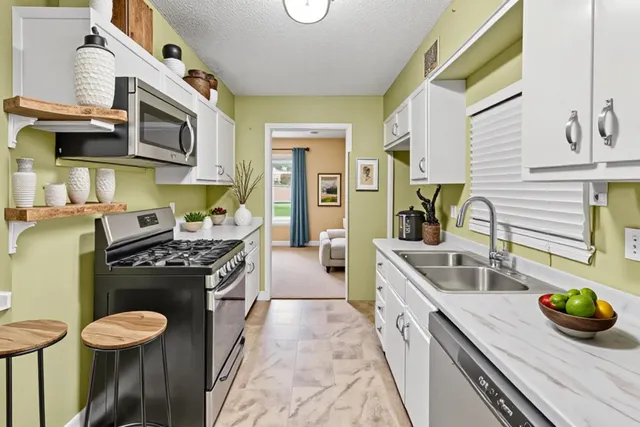 a kitchen with stainless steel appliances granite countertop a stove and a sink