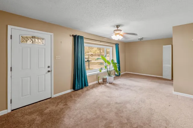 a view of a room with window ceiling fan and refrigerator