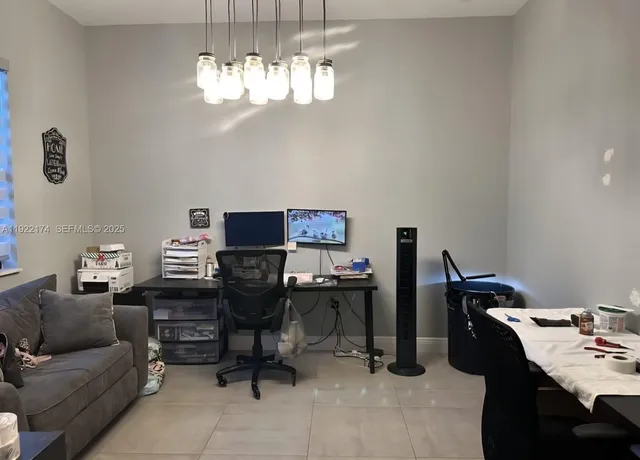 a view of a workspace with furniture and a chandelier