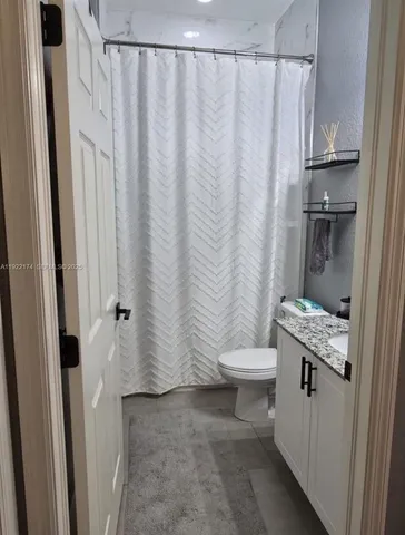 a bathroom with a sink a toilet and shower curtain