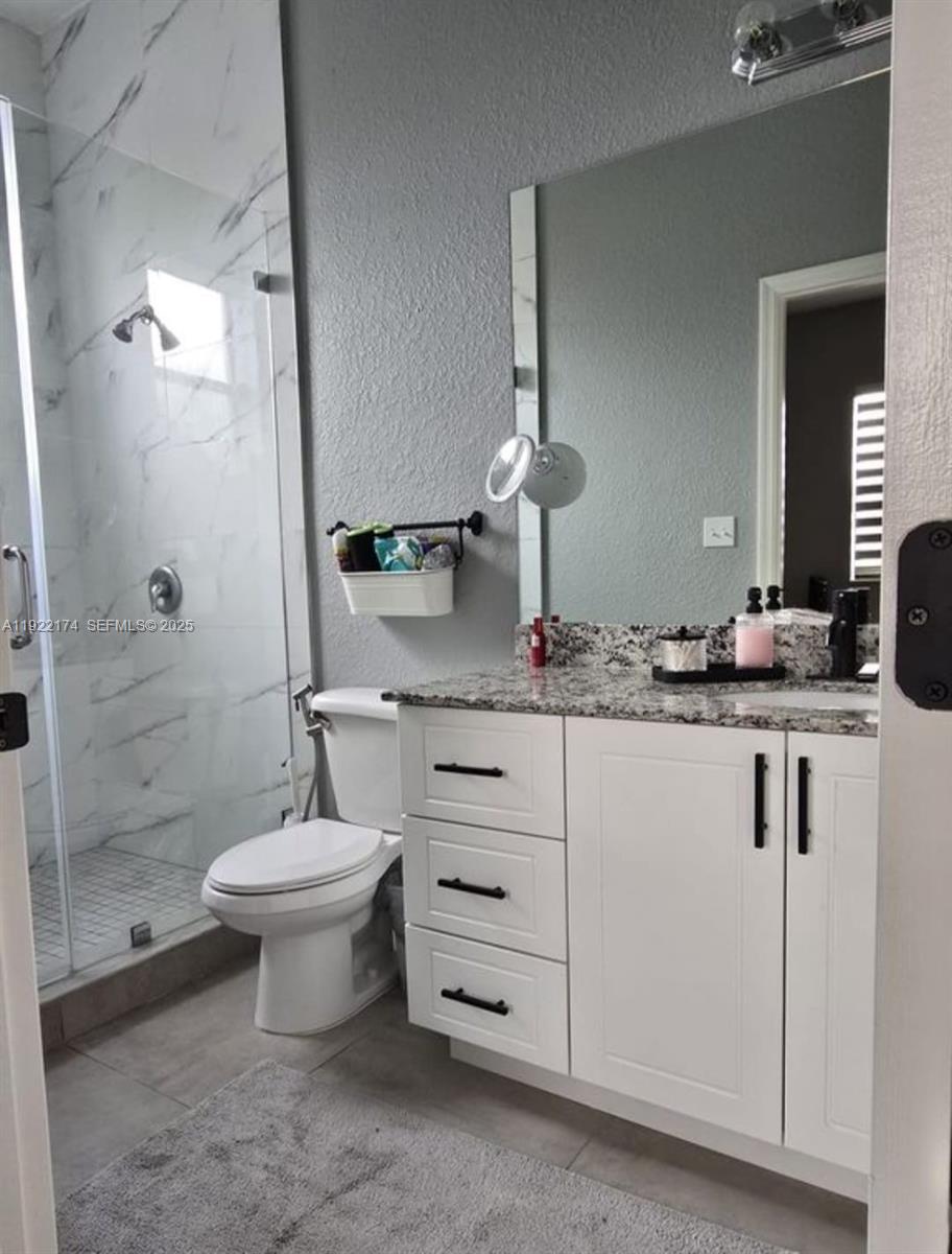 27862 Southwest 134th Court Homestead, FL 33033 - Photo 10 of 14 a bathroom with a double vanity sink a toilet and a shower
