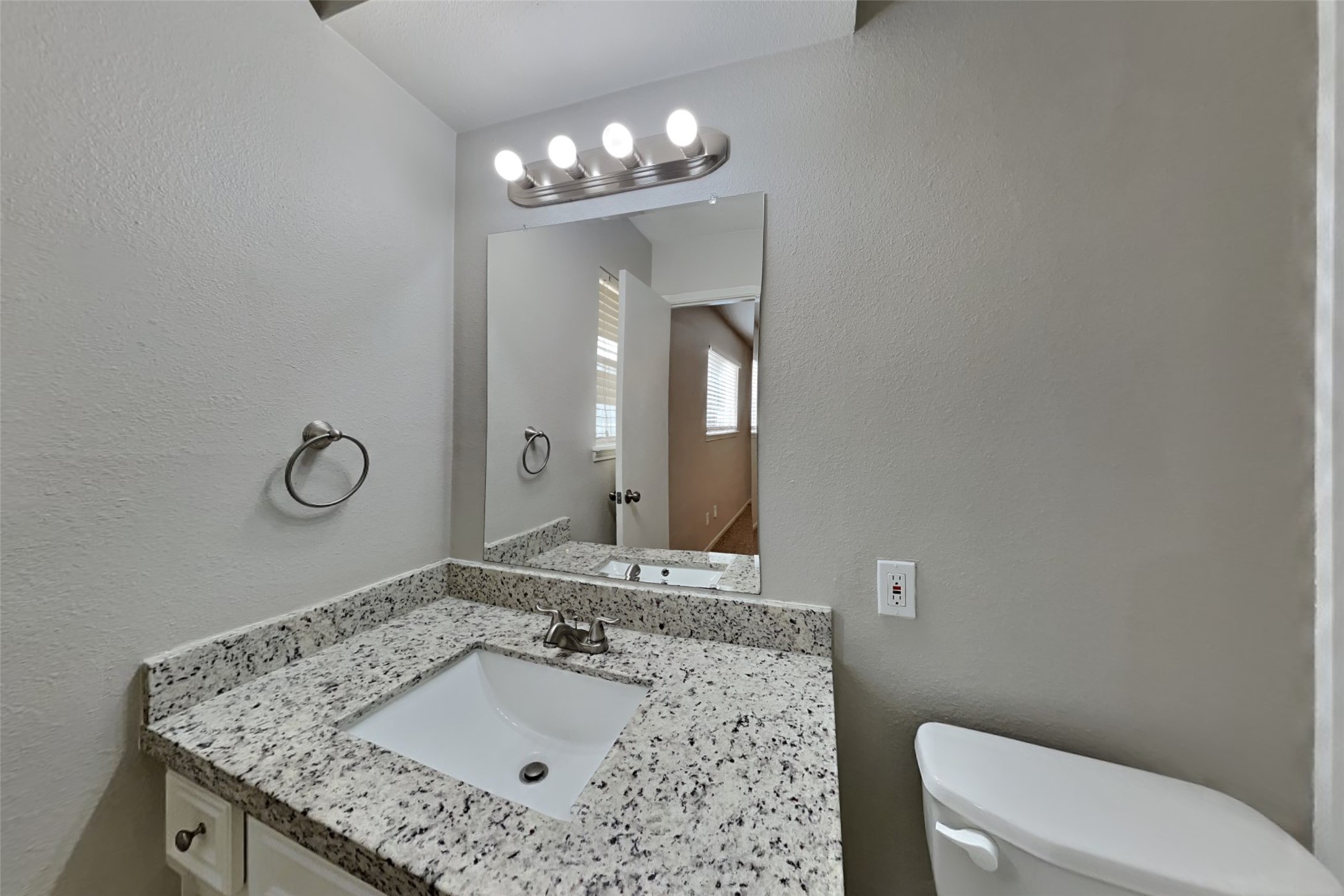 29307 Atherstone Street Spring, TX 77386 - Photo 13 of 22 a bathroom with a granite countertop sink a toilet and a mirror