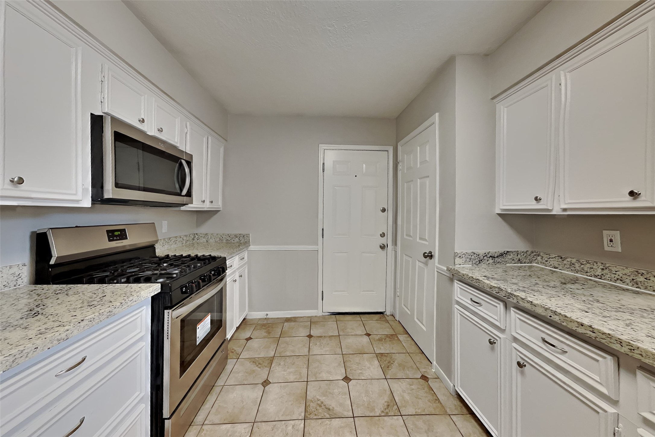 29307 Atherstone Street Spring, TX 77386 - Photo 6 of 22 a kitchen with granite countertop a stove sink and cabinets