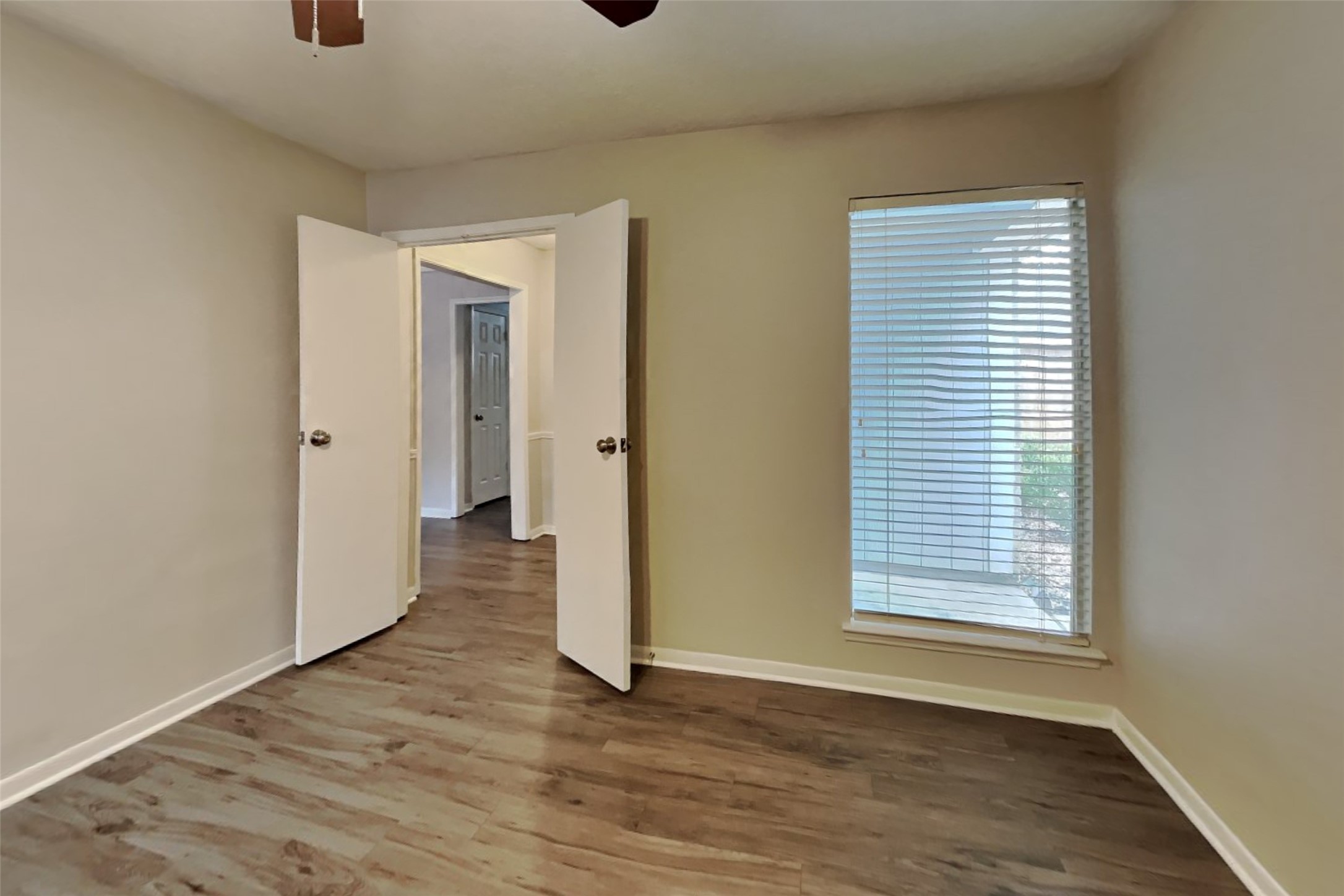 29307 Atherstone Street Spring, TX 77386 - Photo 7 of 22 a view of an empty room with wooden floor and a window