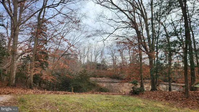 a view of a swimming pool with a chair and wooden fence