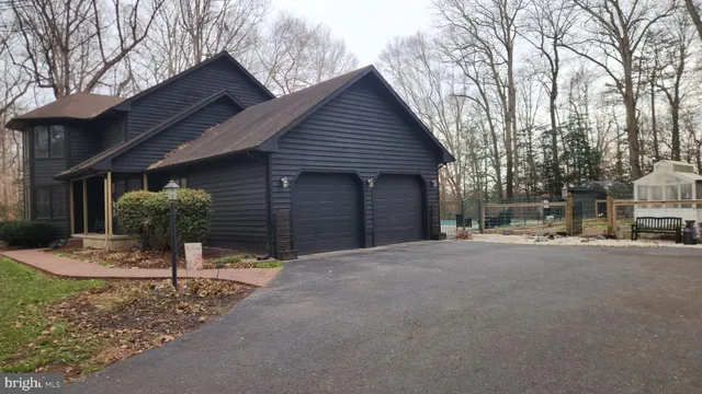 a front view of a house with garden and parking