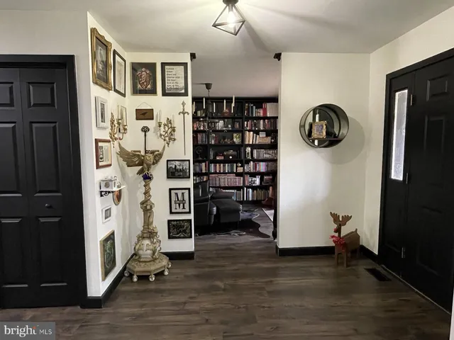 a living room with furniture a bookshelf and a window
