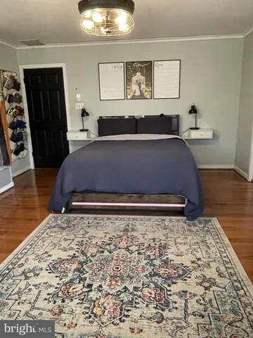 a bedroom with bed and wooden floor