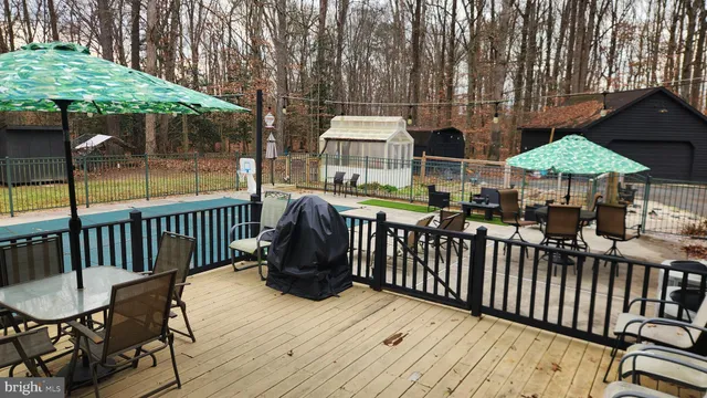 a view of a deck with barbeque grill and furniture