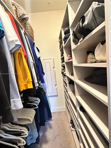 a view of walk in closet with clothes and shoes