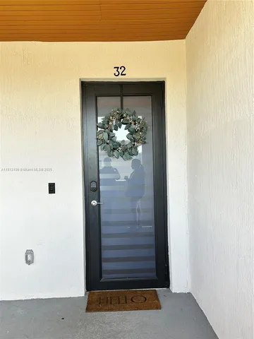 a living room with couches and kitchen view with wooden floor