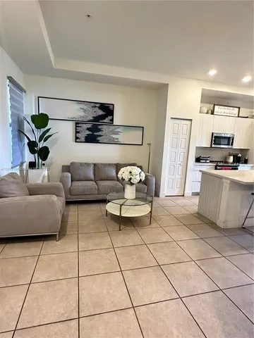 a kitchen with kitchen island a dining table chairs and a wooden floor