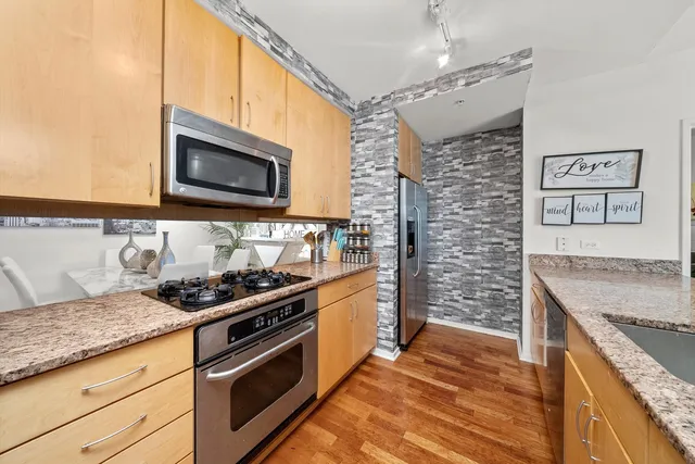 a kitchen with stainless steel appliances granite countertop a stove and a microwave