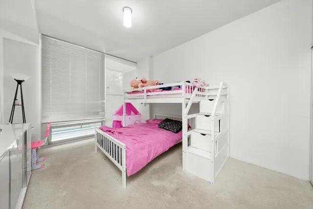 a bedroom with a bed and a white cabinet