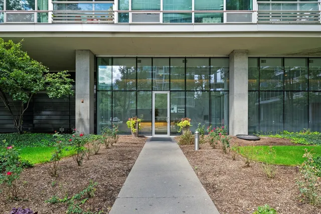 a view of a brick house with a yard and plants