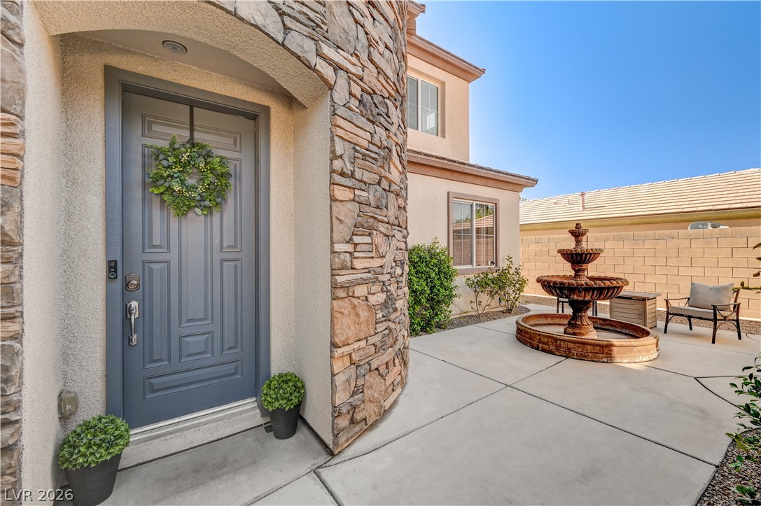 2793 Rosenhearty Drive Henderson, NV 89044 - Photo 33 of 85 A welcoming stone and stucco facade greets with a charming entry and a bubbling tiered fountain in the adjacent courtyard.