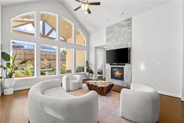 a kitchen with stainless steel appliances kitchen island granite countertop a refrigerator a stove top oven a sink dishwasher and white cabinets with wooden floor