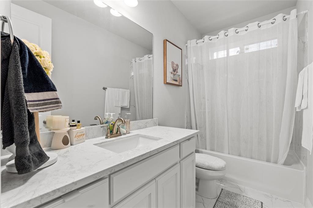 3516 Ithaca Street Corinth, TX 76208 - Photo 23 of 40 a bathroom with a sink a toilet and mirror