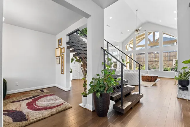 a living room with couches a coffee table and chairs with wooden floor