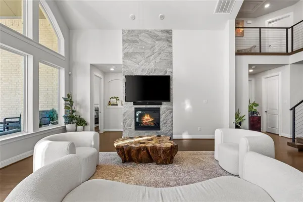 a living room with furniture a flat screen tv and a large window