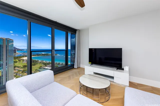 a living room with furniture a flat screen tv and a floor to ceiling window