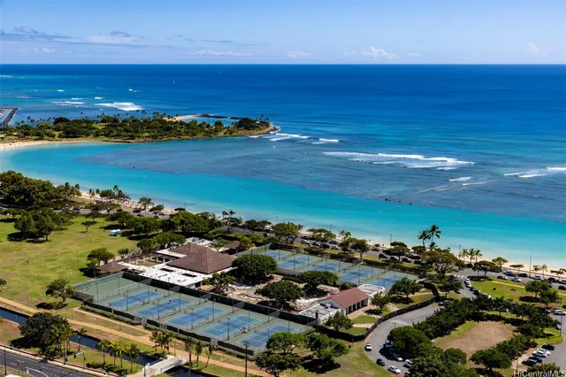 an aerial view of ocean and residential houses with outdoor space